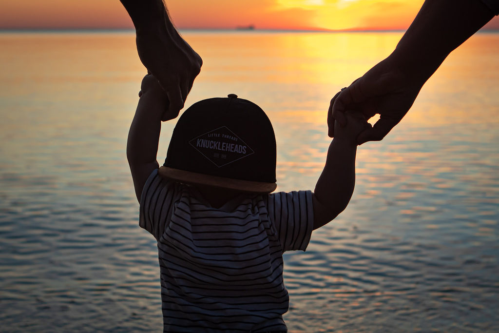 baby holding hands at sunset