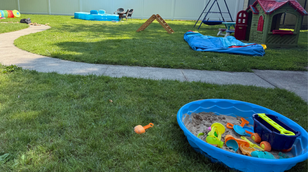 Backyard strewn with various toys and summer fun.